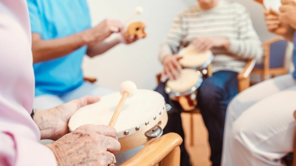 nursing home residents in a group playing the drums