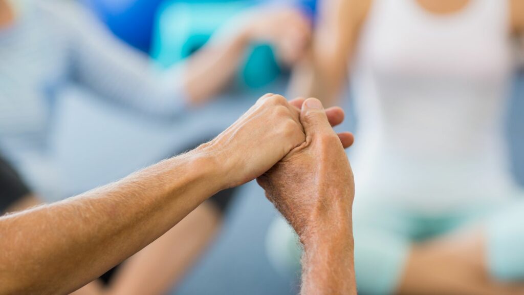 holding hands during group yoga in a nursing home