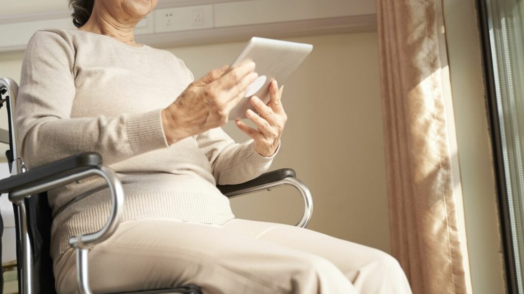 elderly woman holding a touch-screen tablet